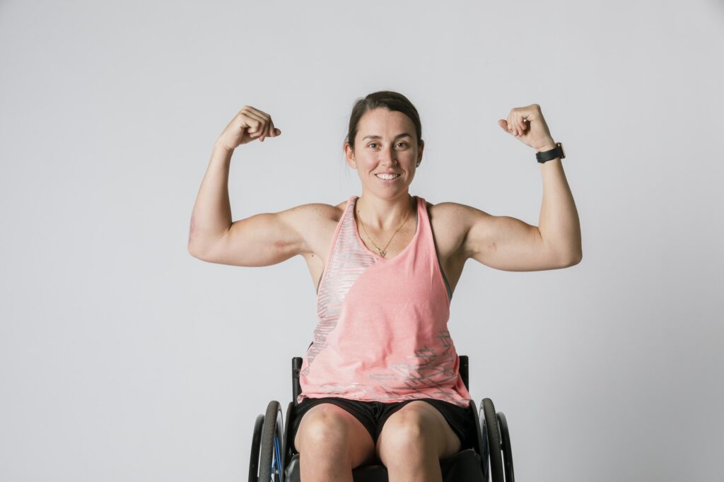 Athlete in a wheelchair flexing her arms