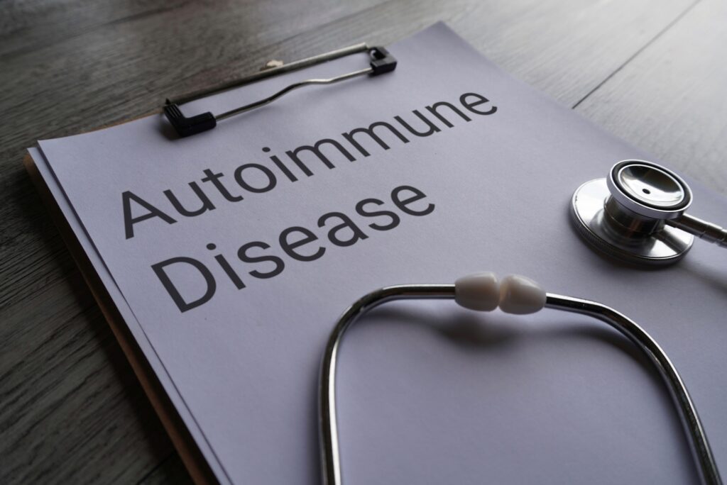Closeup image of stethoscope and paper clipboard with text AUTOIMMUNE DISEASE.